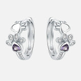 Silver paw print earrings with zirconia and a heart-shaped gemstone.
